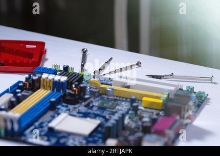 Computer repair. Motherboard repair. Motherboard and repair tools on the mechanic's table. Stock Photo