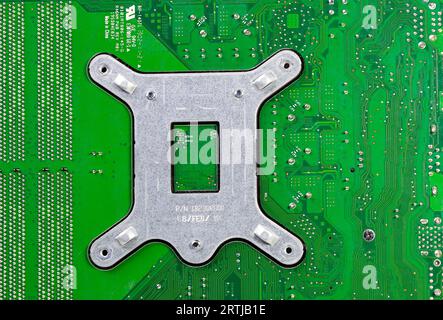 Stainless steel computer heat sink retention bracket plate for CPU cooling system installed on mainboard. Stock Photo