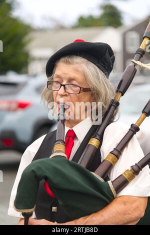 911 commemoration ceremony at Barnstable, MA Fire Headquarters on Cape Cod, USA. A woman bagpiper at the event Stock Photo