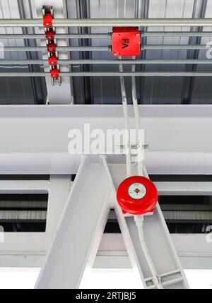 Red Fire alarm bell installed on the wall of public place. Stock Photo