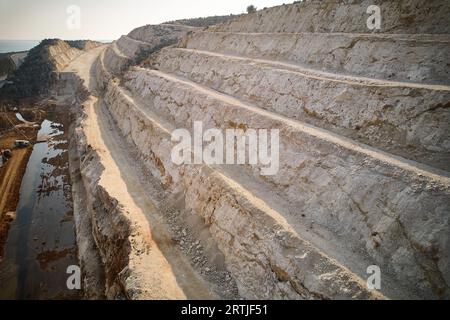 Aerial view of highway ledges under construction after drilling and blasting operations. Road construction at rough highland terrain. Supports of brid Stock Photo