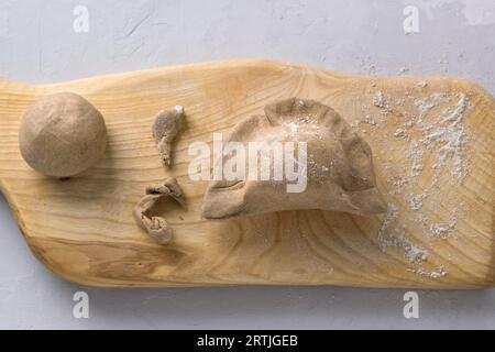 Making pies from rye dough on a wooden board, top view. Cooking stage. Stock Photo