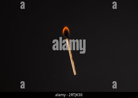 Lit and falling match on a black background. Stock Photo