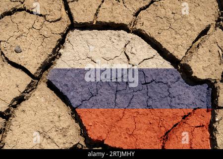 Ecological concept. Drought. On dry, cracked ground, the image of the flag of Russia. Stock Photo