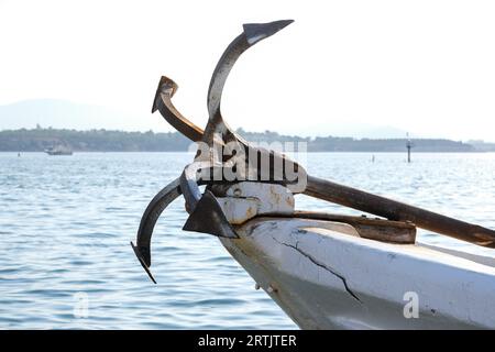Close up old iron anchor on the boat with sea and sky background. Open space area. Stock Photo
