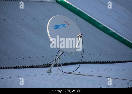 A TV satellite dish mounted on the roof of house at austagram in Kishorganj. Bangladesh Stock Photo