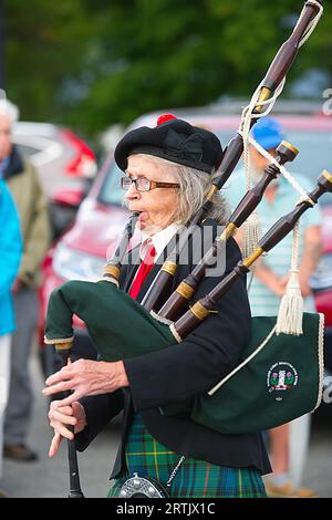 911 commemoration ceremony at Brewster, MA Fire Headquarters on Cape Cod, USA. A bagpiper parades through the crowd. Stock Photo