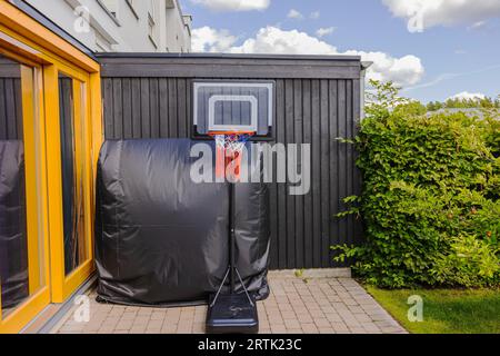 View of basketball hoop with net set up in yard of private villa. Sweden. Stock Photo