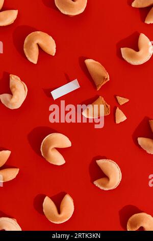 Fortune cookies on red background with deep long shadows. Blank paper for prediction words Stock Photo