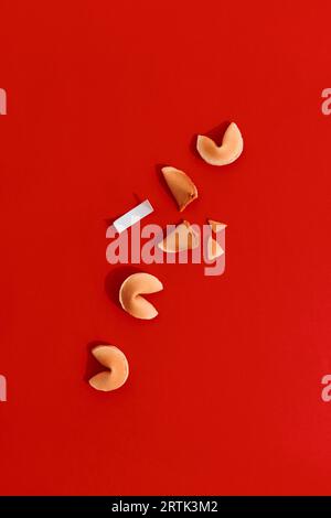 Fortune cookies on red background with deep long shadows. Blank paper for prediction words Stock Photo