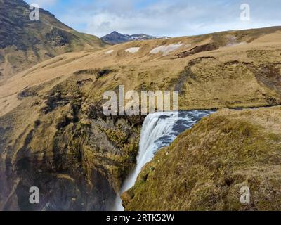 Icelandic frozen cold cascade water, river flow pouring down off scandinavian rocky hills edges. Majestic nordic skgafoss waterfall falling off cliffs, scenic route in amazing iceland. Stock Photo