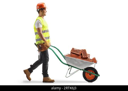 Construction worker pushing a wheelbarrow with bricks isolated on white background Stock Photo