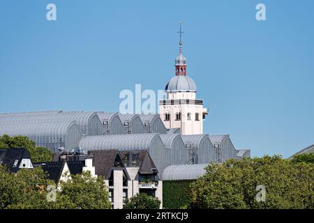 the elegant waves of the Museum Ludwig in cologne's old town in front of the church tower of the Church Of The Assumption in the background Stock Photo