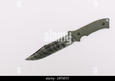 A hunting knife placed on a white background, top view shot. Stock Photo