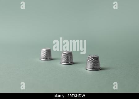 Three thimbles on pale olive background. Thimblerig game Stock Photo ...
