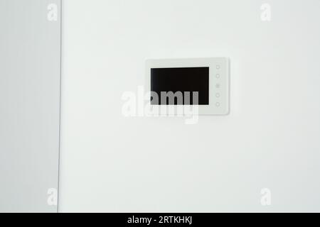 Modern video intercom hanging on white wall Stock Photo