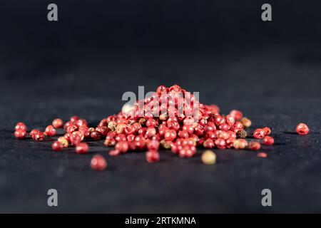 Picture of pink peppercorn, piled in stacked in a macro shot. A pink peppercorn (French: baie rose, "pink berry") is a dried berry referring to three Stock Photo