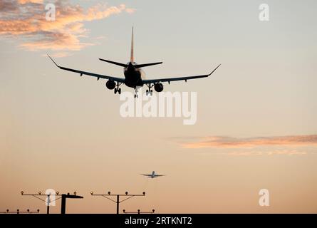 Plane with landing gear down approaching LAX airport as another plane is just taking off in Los Angeles California, USA Stock Photo