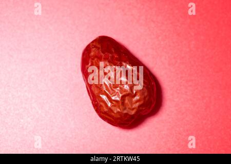 Red dates on a red background, concept of healthy diet Stock Photo