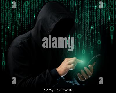 Hackers work on phone in the dark. The concept of information security in the Internet network and information espionage. Virus attack. Hacker attack. Stock Photo