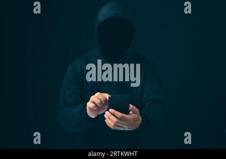 Hackers work on phone in the dark. The concept of information security in the Internet network and information espionage. Virus attack. Hacker attack. Stock Photo