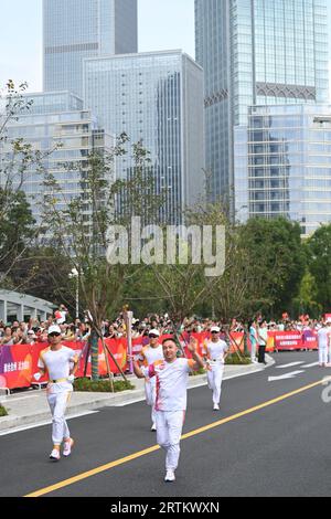 Taizhou, China's Zhejiang Province. 14th Sep, 2023. Torch bearer Yang Wenjie runs with the torch during the torch relay of the 19th Asian Games in Taizhou, east China's Zhejiang Province, Sept. 14, 2023. Credit: Huang Zongzhi/Xinhua/Alamy Live News Stock Photo