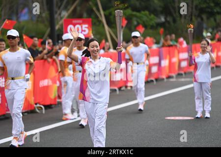 Taizhou, China's Zhejiang Province. 14th Sep, 2023. Torch bearer Feng Yu runs with the torch during the torch relay of the 19th Asian Games in Taizhou, east China's Zhejiang Province, Sept. 14, 2023. Credit: Huang Zongzhi/Xinhua/Alamy Live News Stock Photo