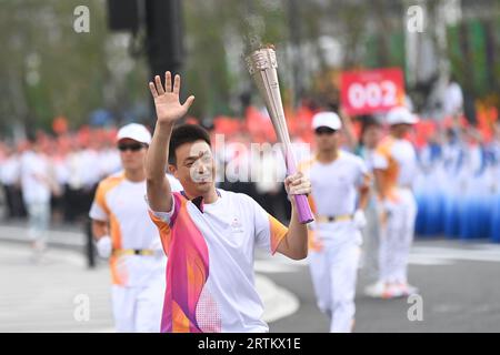 Taizhou, China's Zhejiang Province. 14th Sep, 2023. Torch bearer Lyu Yicong runs with the torch during the torch relay of the 19th Asian Games in Taizhou, east China's Zhejiang Province, Sept. 14, 2023. Credit: Huang Zongzhi/Xinhua/Alamy Live News Stock Photo