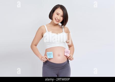 Belly of a young pregnant woman with a white sticker and a question on it (boy or girl concept) Stock Photo
