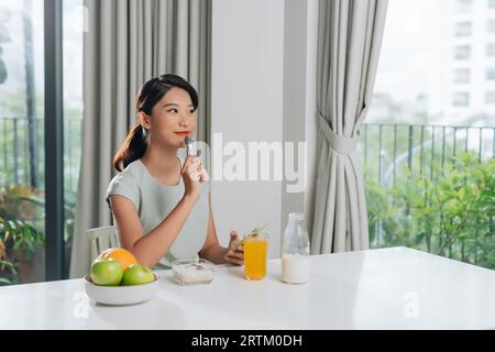Happy woman using smartphone with food at table Stock Photo