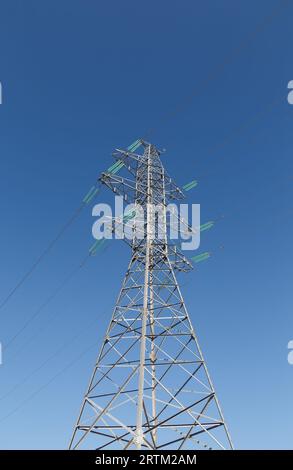 High pylon of a power line against the blue sky Stock Photo