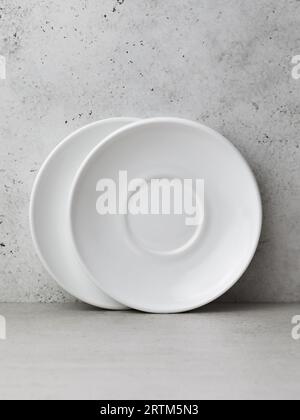 Two white ceramic saucers on the table Stock Photo