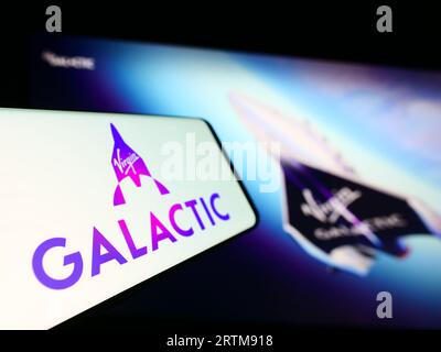 Smartphone with logo of American spaceflight company Virgin Galactic on screen in front of website. Focus on center-left of phone display. Stock Photo