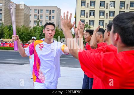 Taizhou, China's Zhejiang Province. 14th Sep, 2023. Torch bearer Wu Yirui runs with the torch during the torch relay of the 19th Asian Games in Taizhou, east China's Zhejiang Province, Sept. 14, 2023. Credit: Sun Fei/Xinhua/Alamy Live News Stock Photo