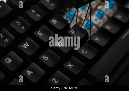 Close-up of a cleaning in progress of a mechanical keyboard with blue switched, full of debris. Stock Photo