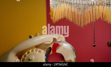 Old telephone and a lamp with rhinestones. Yellow and red background. Stock Photo