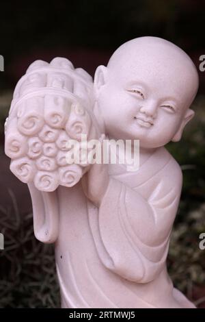 Linh Chieu Zen Monastery. Young buddhist monk in garden. Marble statue.  Vung Tau. Vietnam. Stock Photo