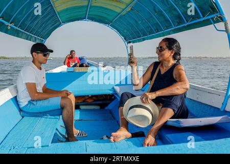 Mother and son on a boat cruising in the Saloum river delta, Senegal Stock Photo