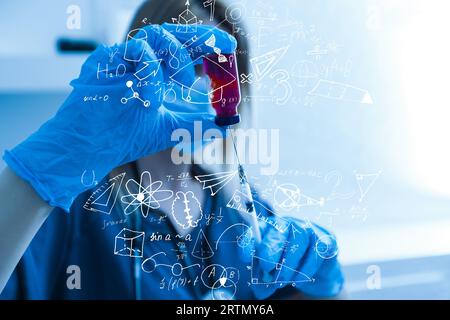 science, research and chemistry concept - young scientist in safety glasses with test tube and virtual projection of chemical formula. Stock Photo