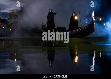 EDITORIAL USE ONLY Two cloaked figures operate a traditional Venetian Gondola in Camden Lock to celebrate the launch of the new 20th Century Studios film, A Haunting in Venice. Picture date: Thursday September 14, 2023. Stock Photo