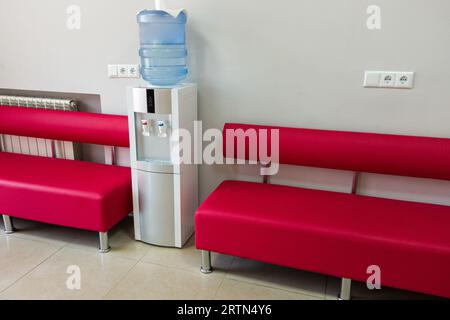Hospital Reception Area with Refreshing Water Cooler. Welcoming hospital reception area, a modern and hygienic water cooler stands as a symbol of care Stock Photo
