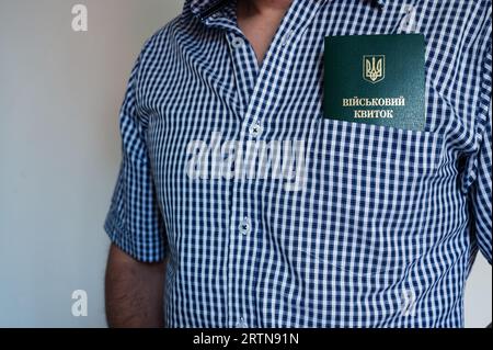 Translation: 'military id'. Civil man in shirt with army document for rookie, veteran, soldier in pocket on white background Stock Photo