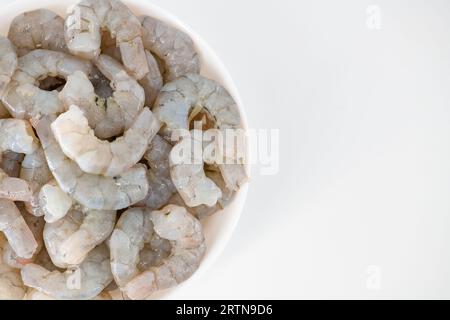 Fresh Raw shrimps cut and cleaned and kept it in a white bowl. Raw shrimps in white bowl and isolated in white background. Selective focused image. Stock Photo