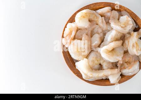 Fresh Raw shrimps cleaned and kept it in a wooden bowl. Raw shrimps in wooden bowl and isolated in white background. Stock Photo