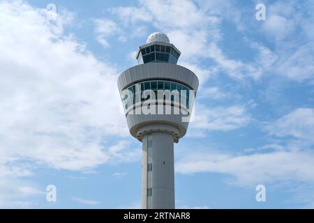 Air control tower on an airport in the Netherlands against a blue sky with clouds Stock Photo