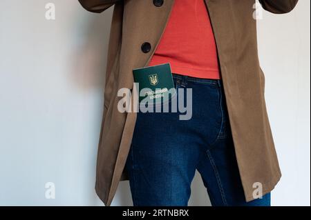 Translation: 'military id'. Civil man in jacket with ukrainian military id in jeans pocket. Stock Photo