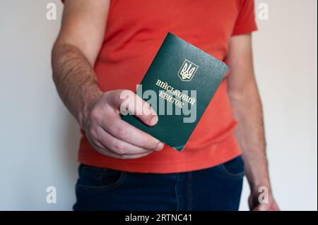 Translation: 'military id'. Civil man holding ukrainian military id. Soldier, mobilization, veteran, rookie, document Stock Photo