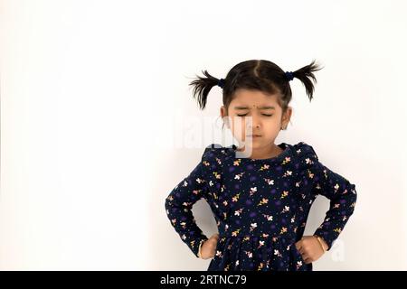 Anxious kid. Failure regret. Disappointment frustration. Portrait of adamant and angry young keeping hands on hip with closed eyes isolated with white Stock Photo