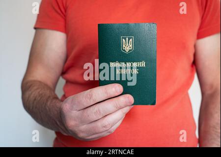 Translation: 'military id'. Civil man holding ukrainian military id. Soldier, mobilization, veteran, rookie, document Stock Photo