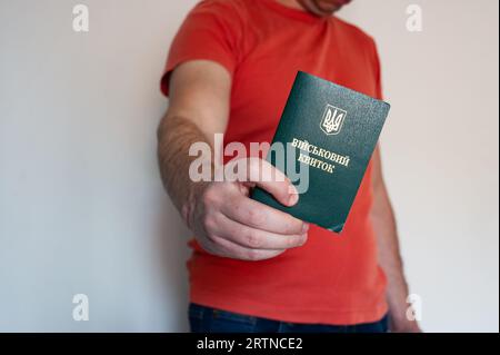 Translation: 'military id'. Civil man holding ukrainian military id. Soldier, mobilization, veteran, rookie, document Stock Photo